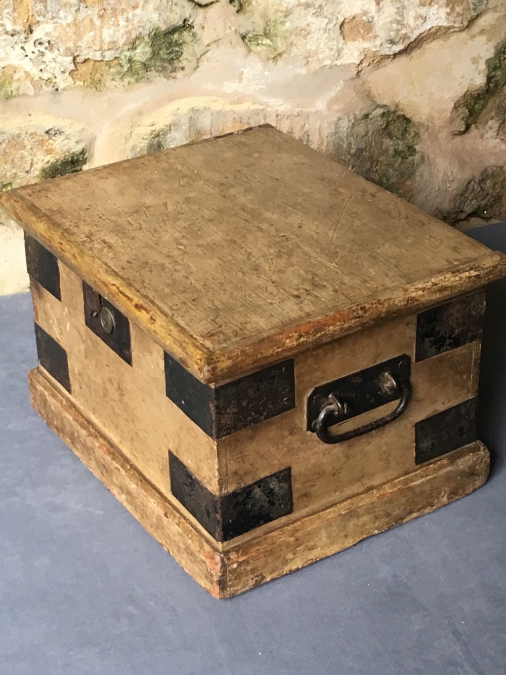 A small Victorian wooden trunk featuring an ochre painted finish, dark iron corner brackets, side handles, and a hinged lid. View XI