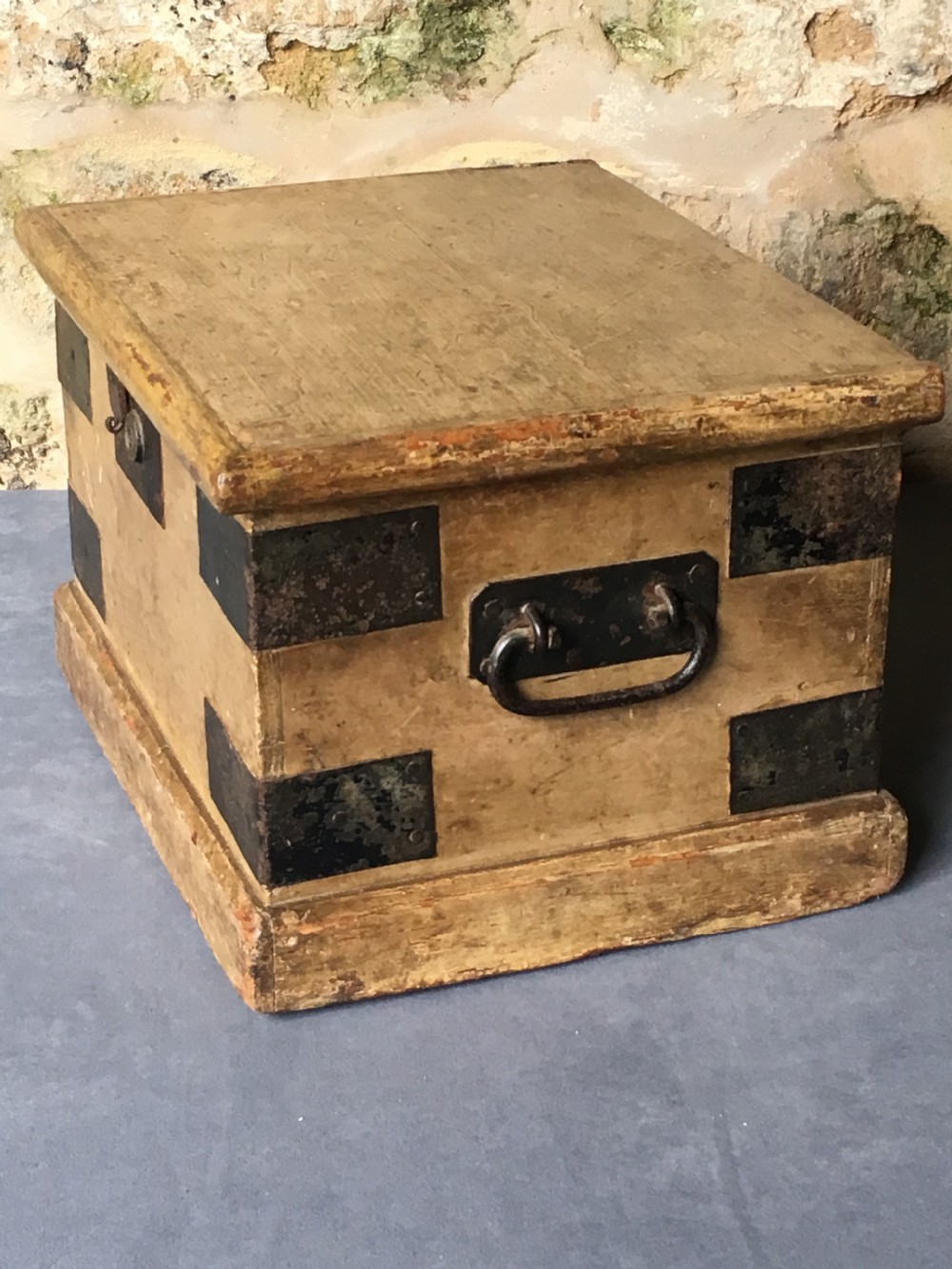 A small Victorian wooden trunk featuring an ochre painted finish, dark iron corner brackets, side handles, and a hinged lid. View XII