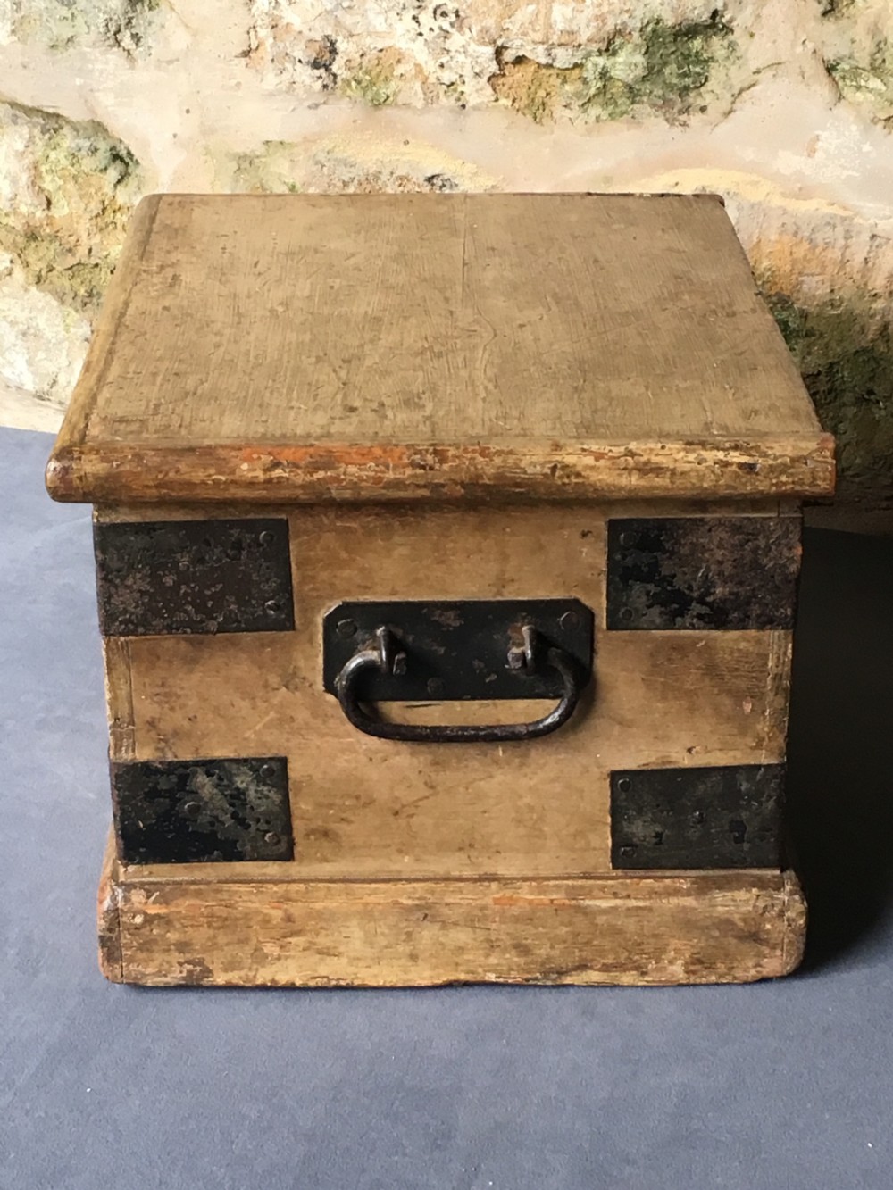 A small Victorian wooden trunk featuring an ochre painted finish, dark iron corner brackets, side handles, and a hinged lid. View XIII