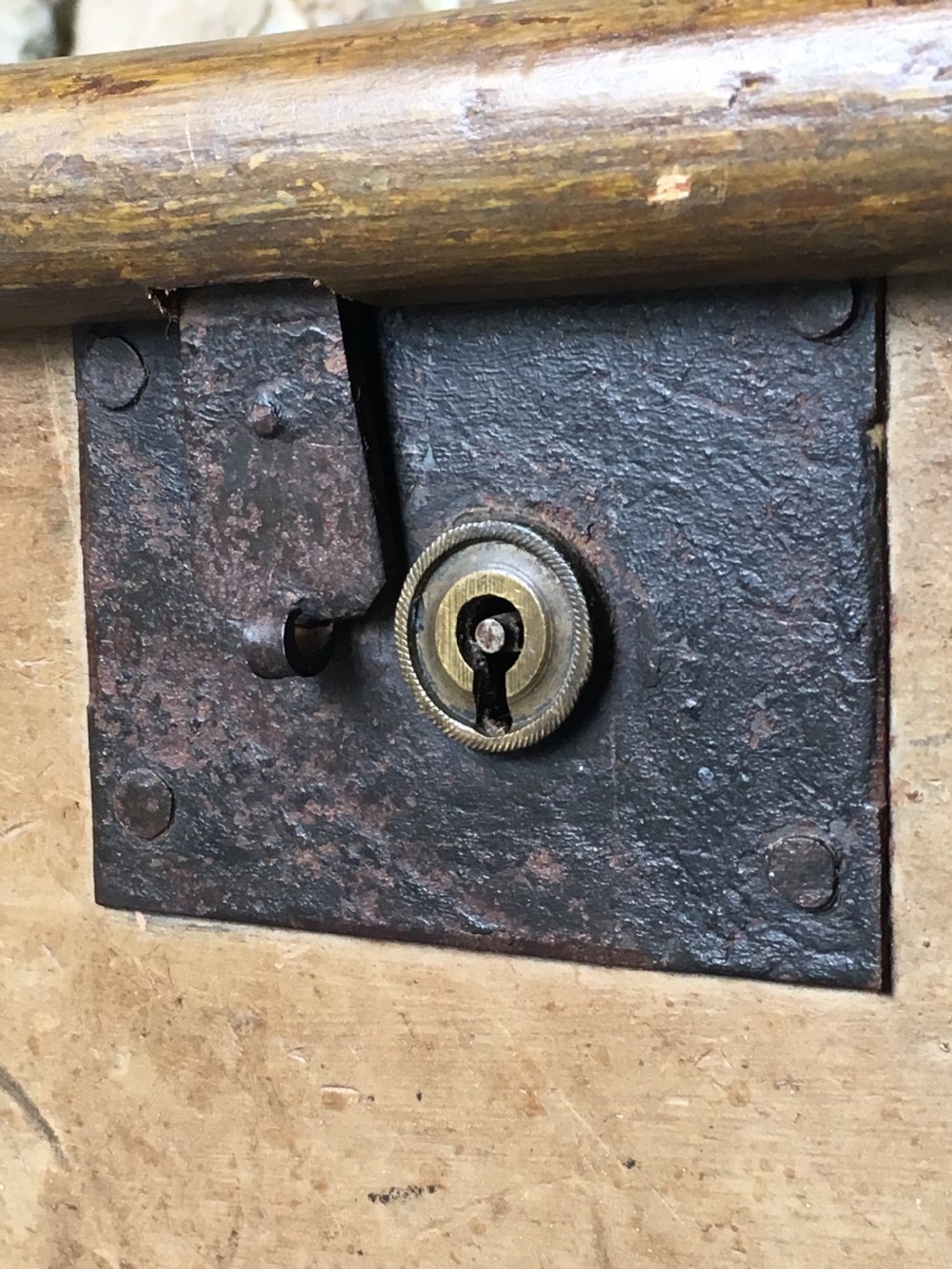 A small Victorian wooden trunk featuring an ochre painted finish, dark iron corner brackets, side handles, and a hinged lid. View XV
