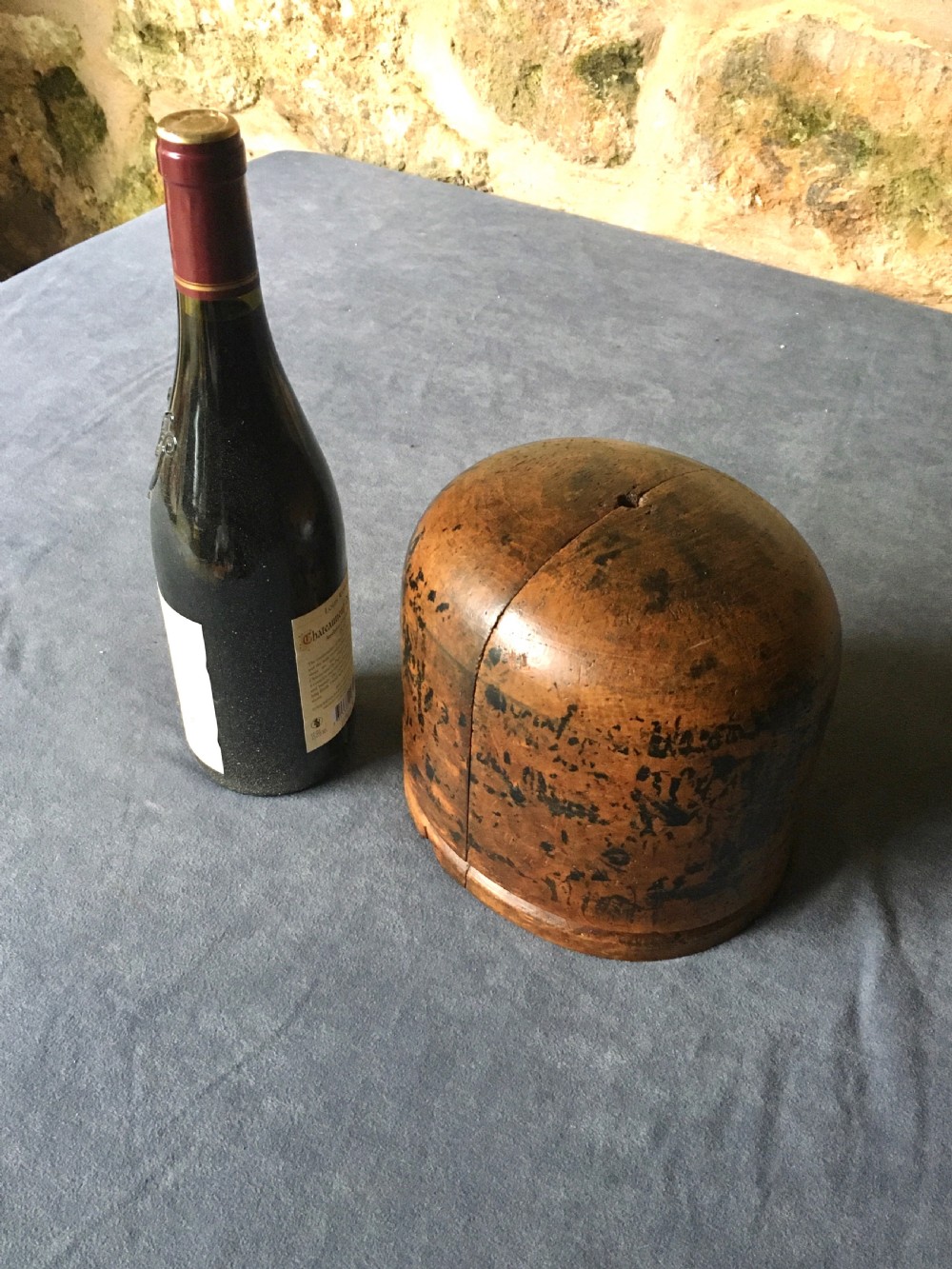 A two-piece carved wooden milliners hat block featuring a rounded dome top and a weathered brown and black painted finish. View II