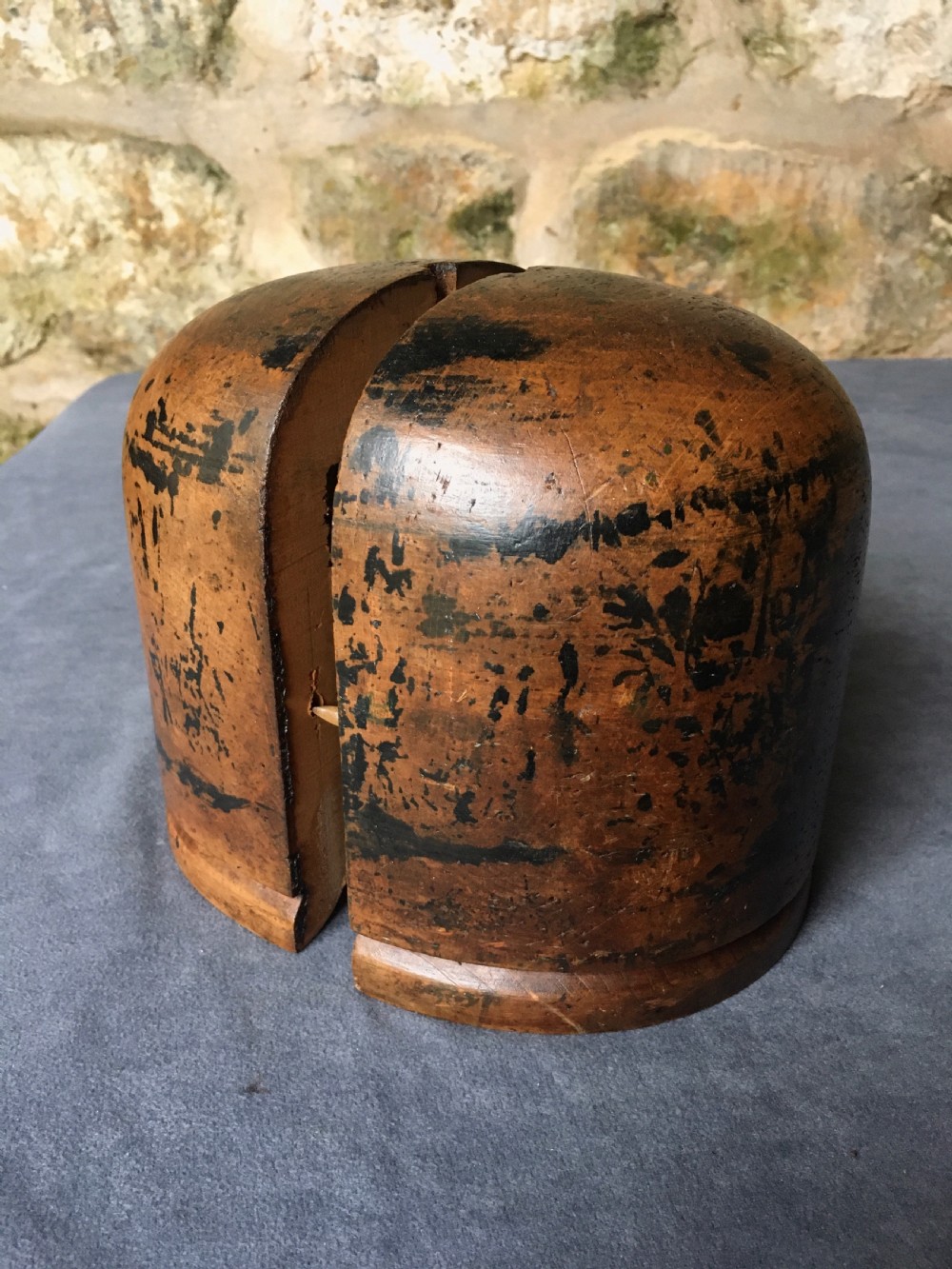 A two-piece carved wooden milliners hat block featuring a rounded dome top and a weathered brown and black painted finish. View IV