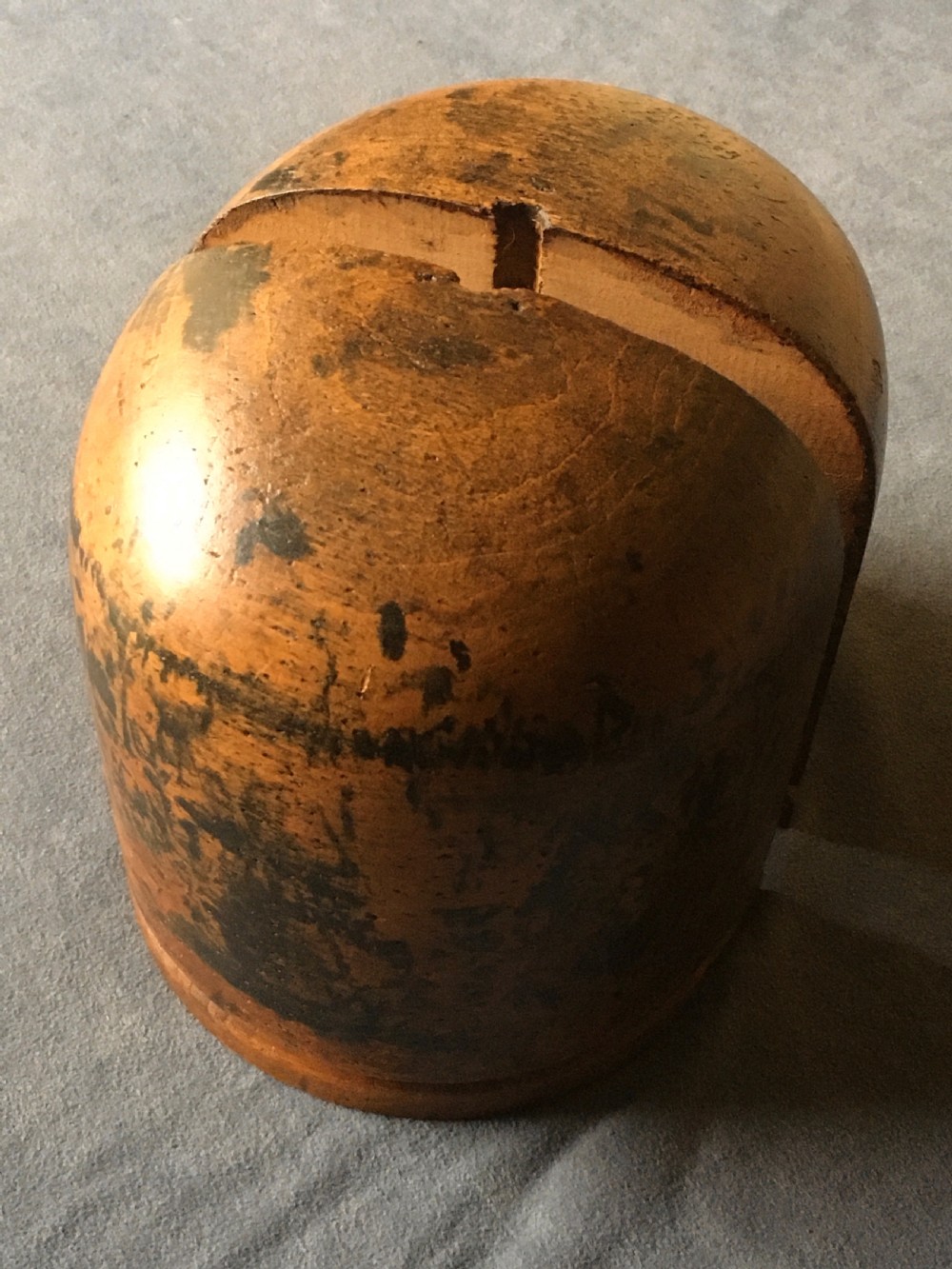 A two-piece carved wooden milliners hat block featuring a rounded dome top and a weathered brown and black painted finish. View VI