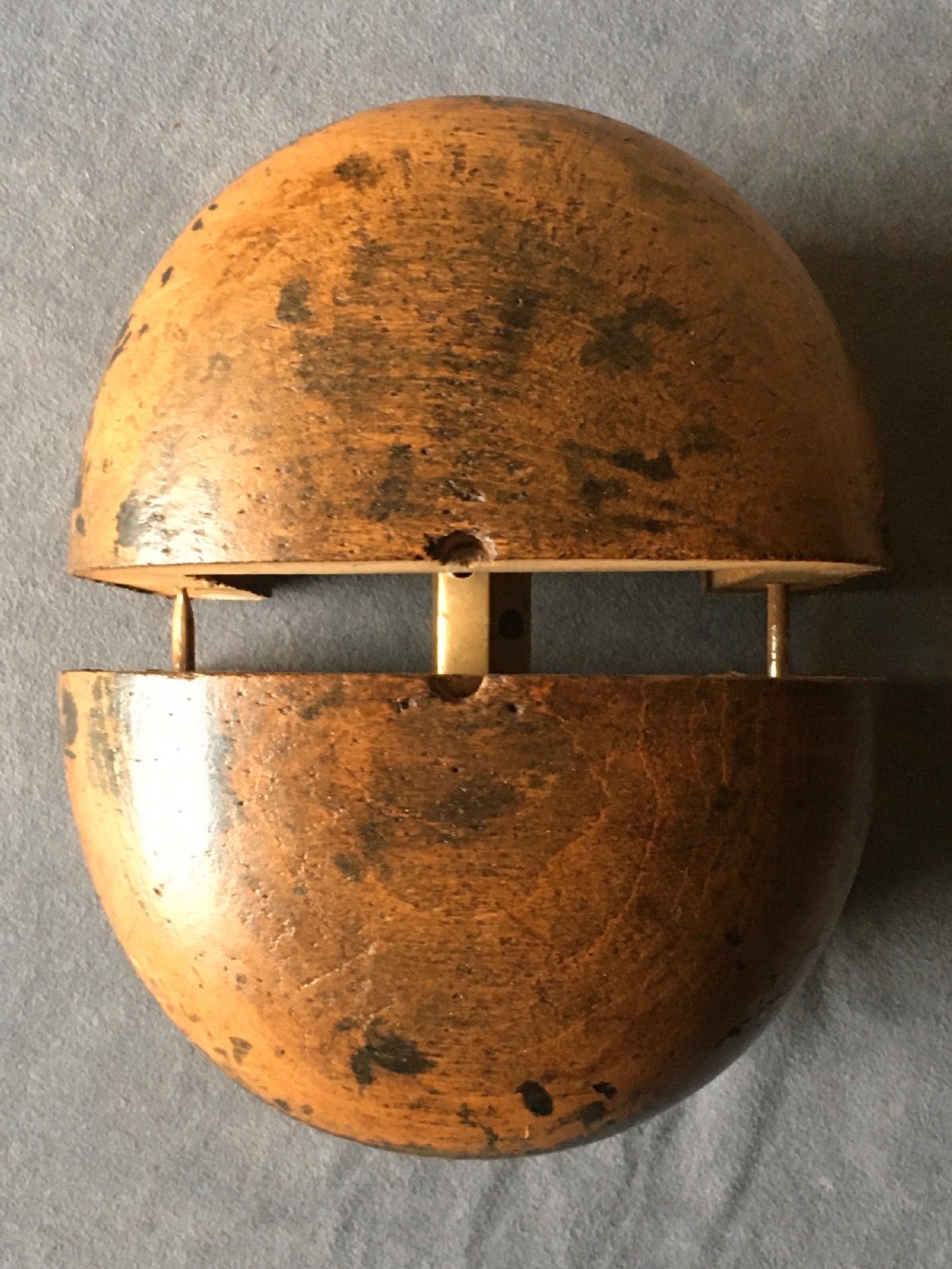 A two-piece carved wooden milliners hat block featuring a rounded dome top and a weathered brown and black painted finish. View VII