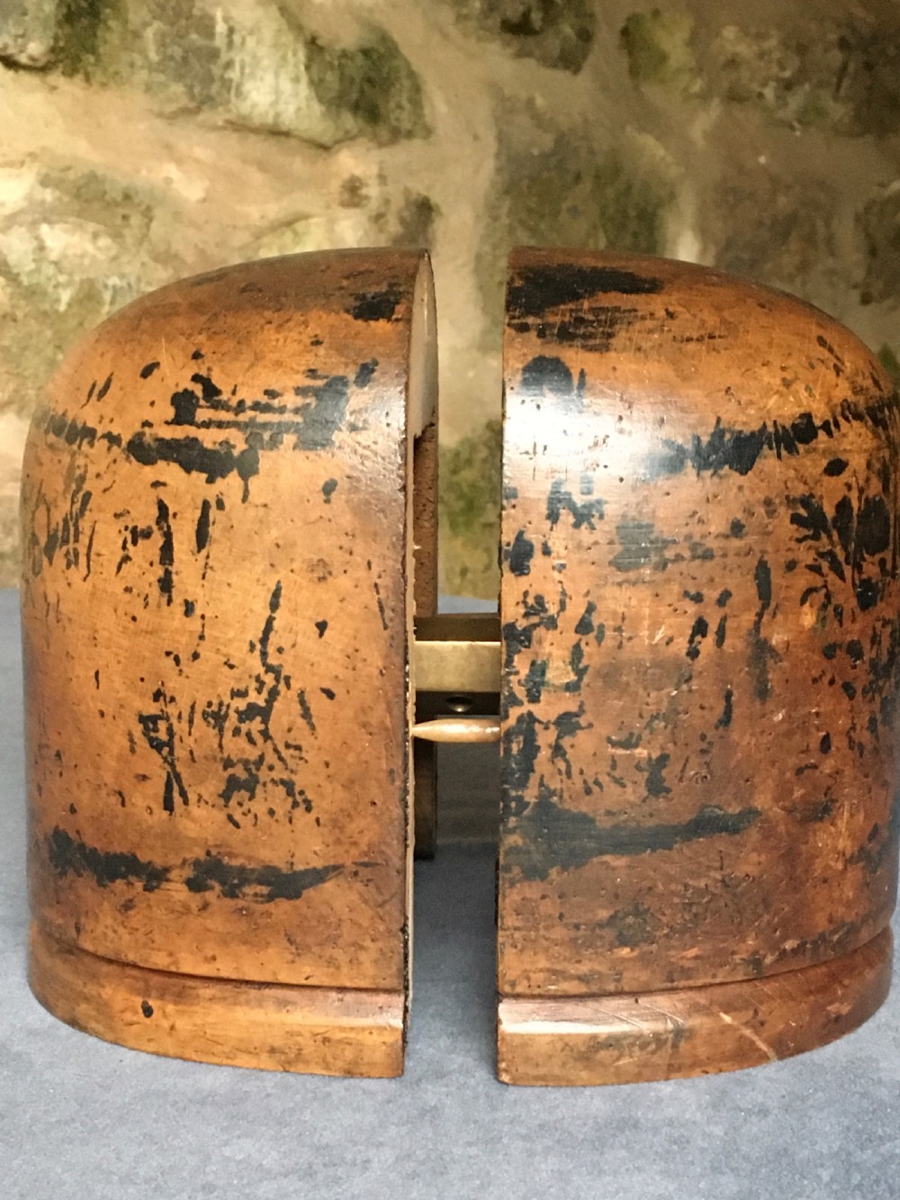 A two-piece carved wooden milliners hat block featuring a rounded dome top and a weathered brown and black painted finish. View VIII