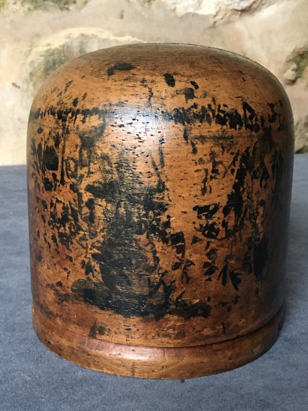 A two-piece carved wooden milliners hat block featuring a rounded dome top and a weathered brown and black painted finish. View XIII