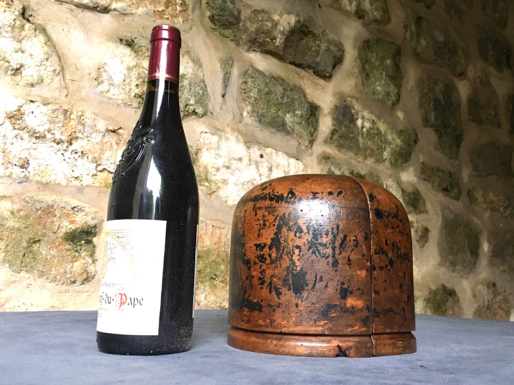 A two-piece carved wooden milliners hat block featuring a rounded dome top and a weathered brown and black painted finish. View XVII