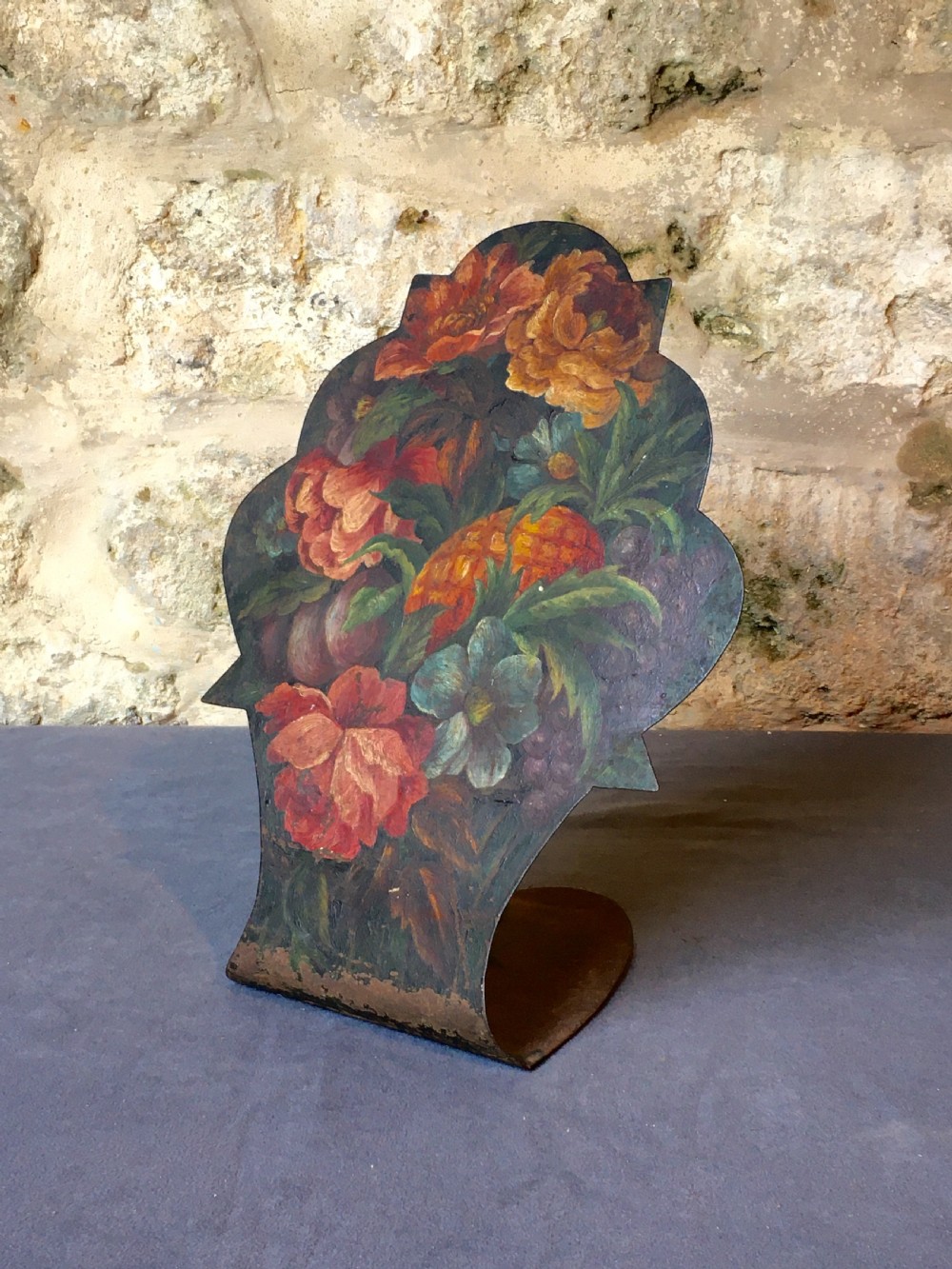 A contoured painted sheet metal stand depicting a botanical floral and fruit still life arrangement. View II