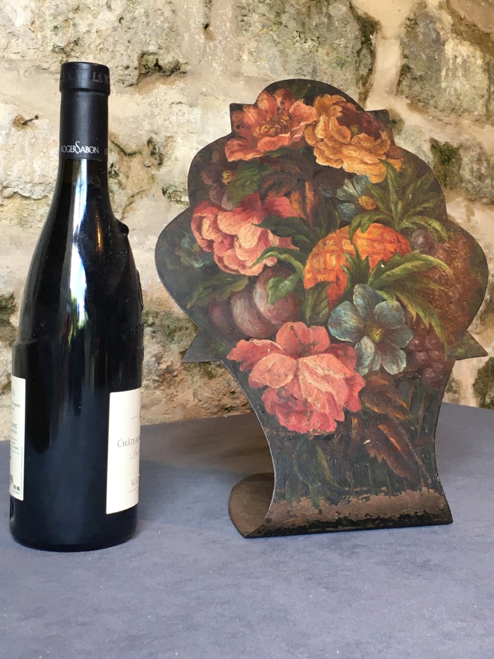 A contoured painted sheet metal stand depicting a botanical floral and fruit still life arrangement. View IV