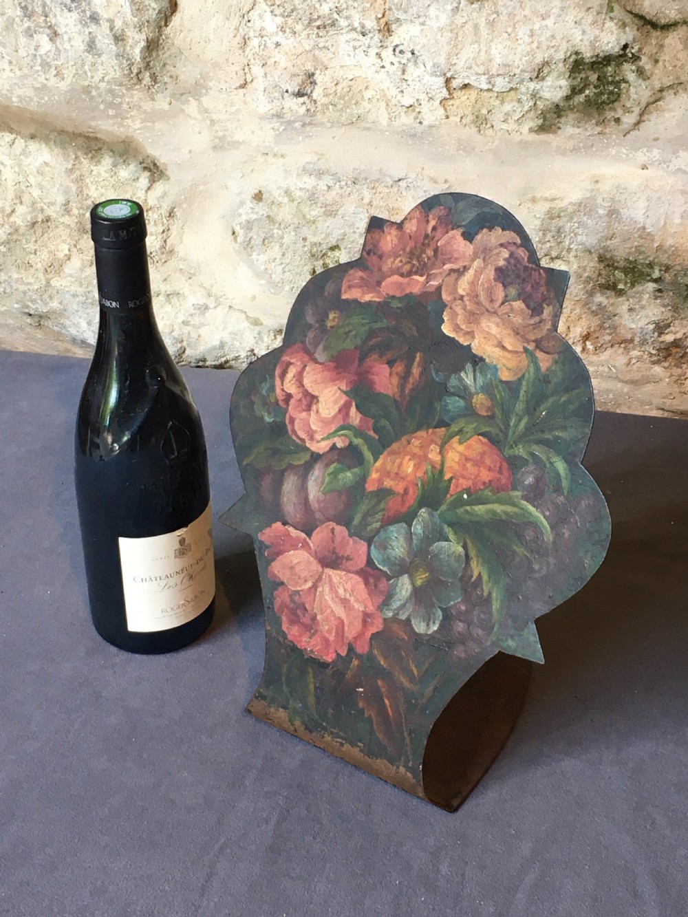 A contoured painted sheet metal stand depicting a botanical floral and fruit still life arrangement. View V