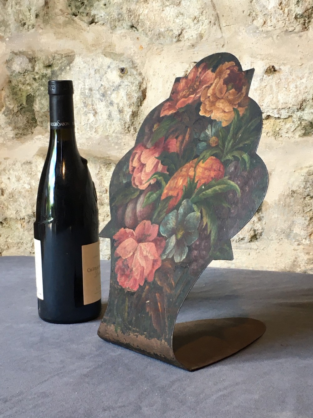 A contoured painted sheet metal stand depicting a botanical floral and fruit still life arrangement. View VI