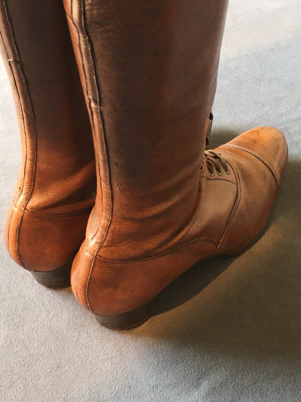 A pair of antique tall brown leather lace-up boots fitted with metal and brass boot shapers. View X