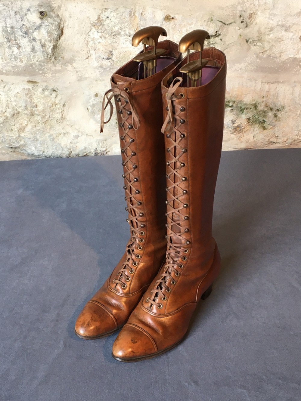 A pair of antique tall brown leather lace-up boots fitted with metal and brass boot shapers. View XI