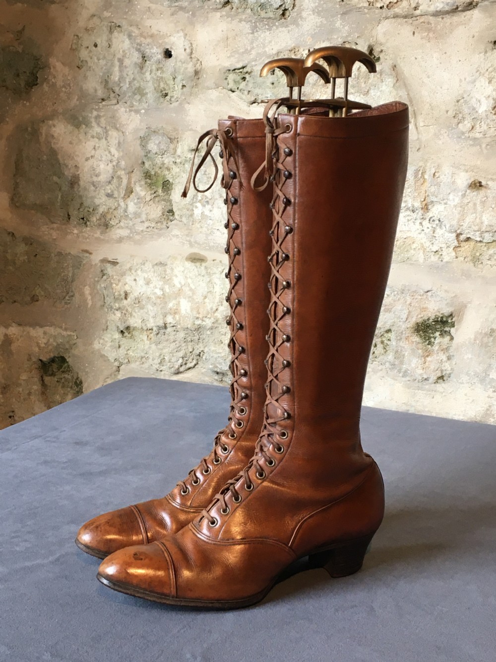 A pair of antique tall brown leather lace-up boots fitted with metal and brass boot shapers. View XII