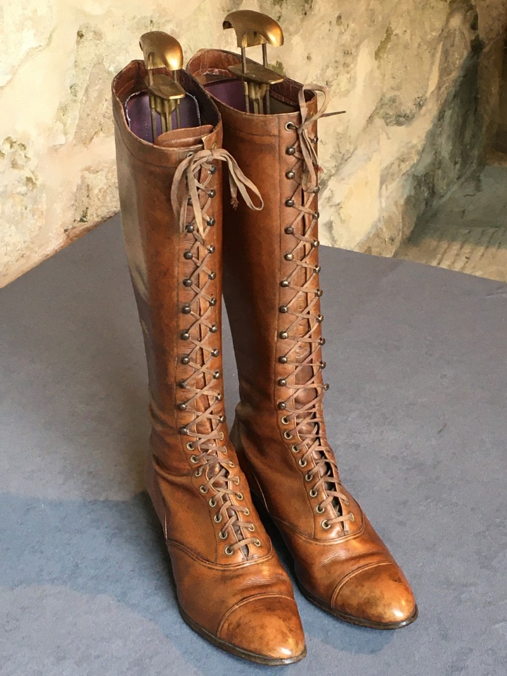 A pair of antique tall brown leather lace-up boots fitted with metal and brass boot shapers. View XV