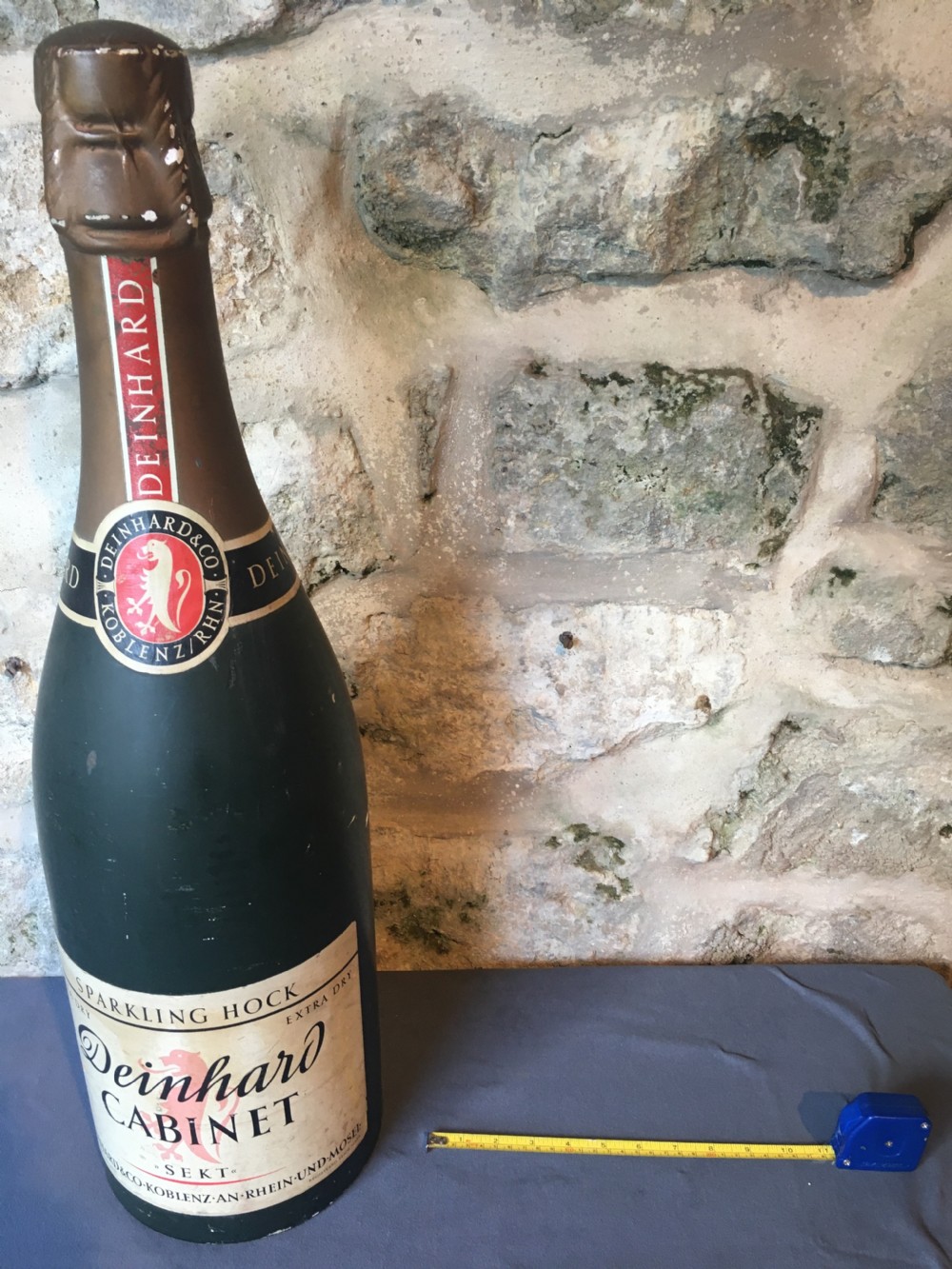 A group of four large vintage dark green glass advertising wine and champagne bottles featuring original paper labels. View XI