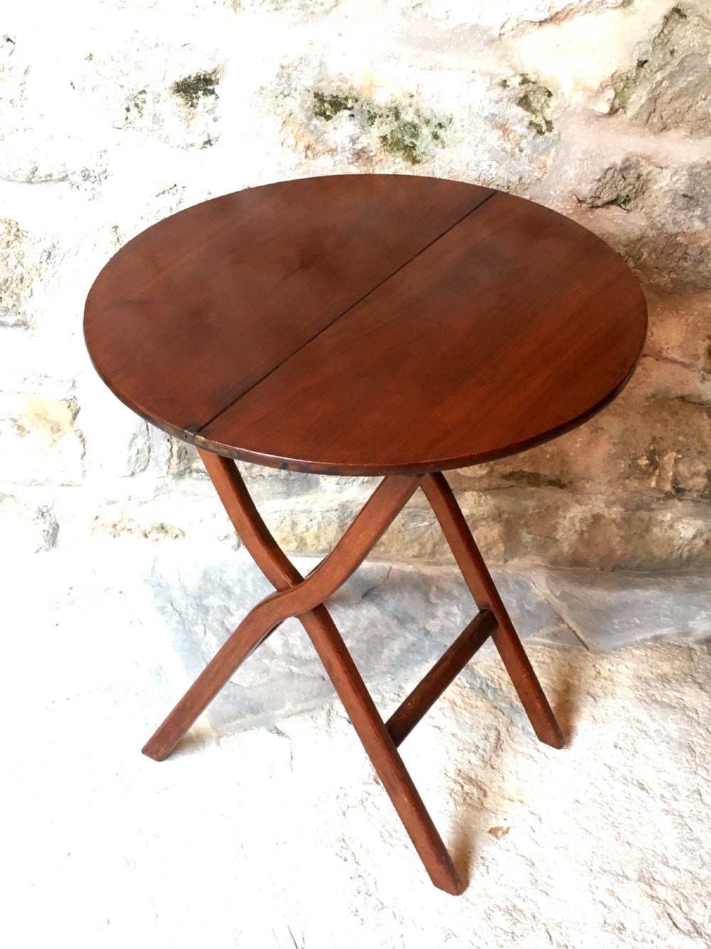 A Victorian mahogany folding occasional table with a hinged circular top supported by curved X-frame legs. View II