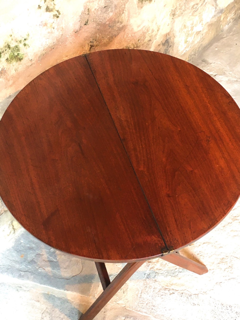 A Victorian mahogany folding occasional table with a hinged circular top supported by curved X-frame legs. View IV