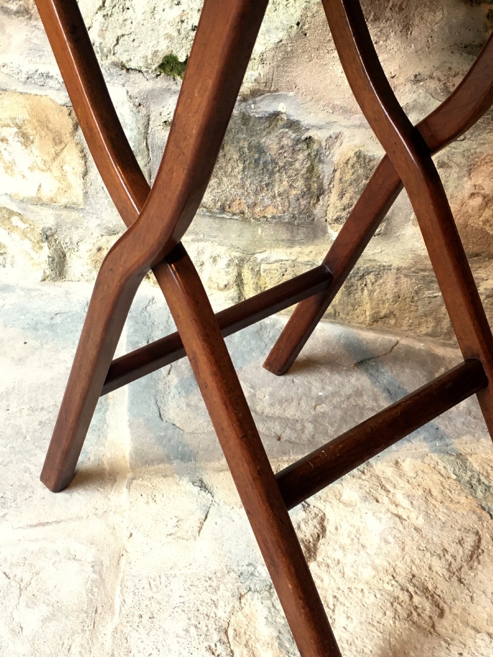 A Victorian mahogany folding occasional table with a hinged circular top supported by curved X-frame legs. View VII