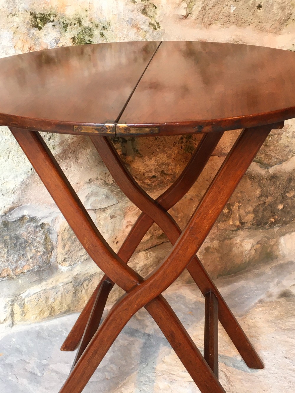 A Victorian mahogany folding occasional table with a hinged circular top supported by curved X-frame legs. View VIII