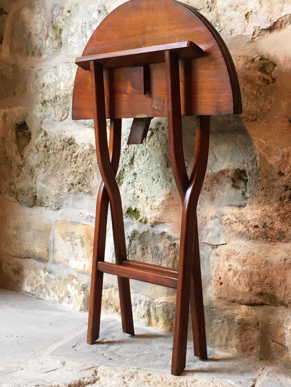 A Victorian mahogany folding occasional table with a hinged circular top supported by curved X-frame legs. View XX