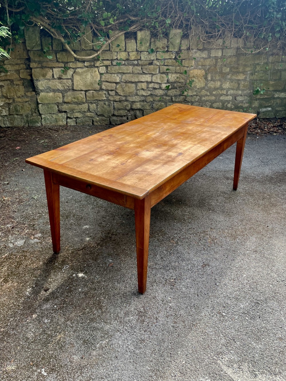 A rectangular wooden refectory dining table with a plank top, breadboard ends, and four tapered legs. View II