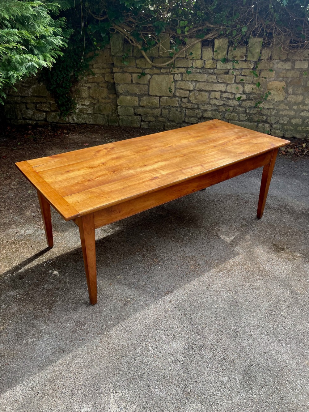 A rectangular wooden refectory dining table with a plank top, breadboard ends, and four tapered legs. View III