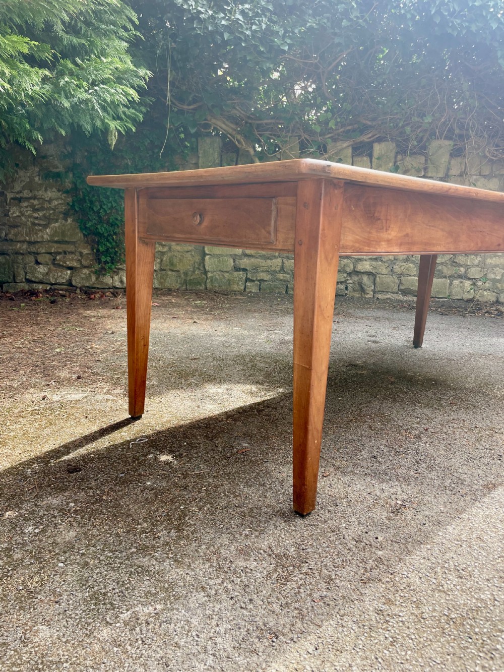 A rectangular wooden refectory dining table with a plank top, breadboard ends, and four tapered legs. View IV