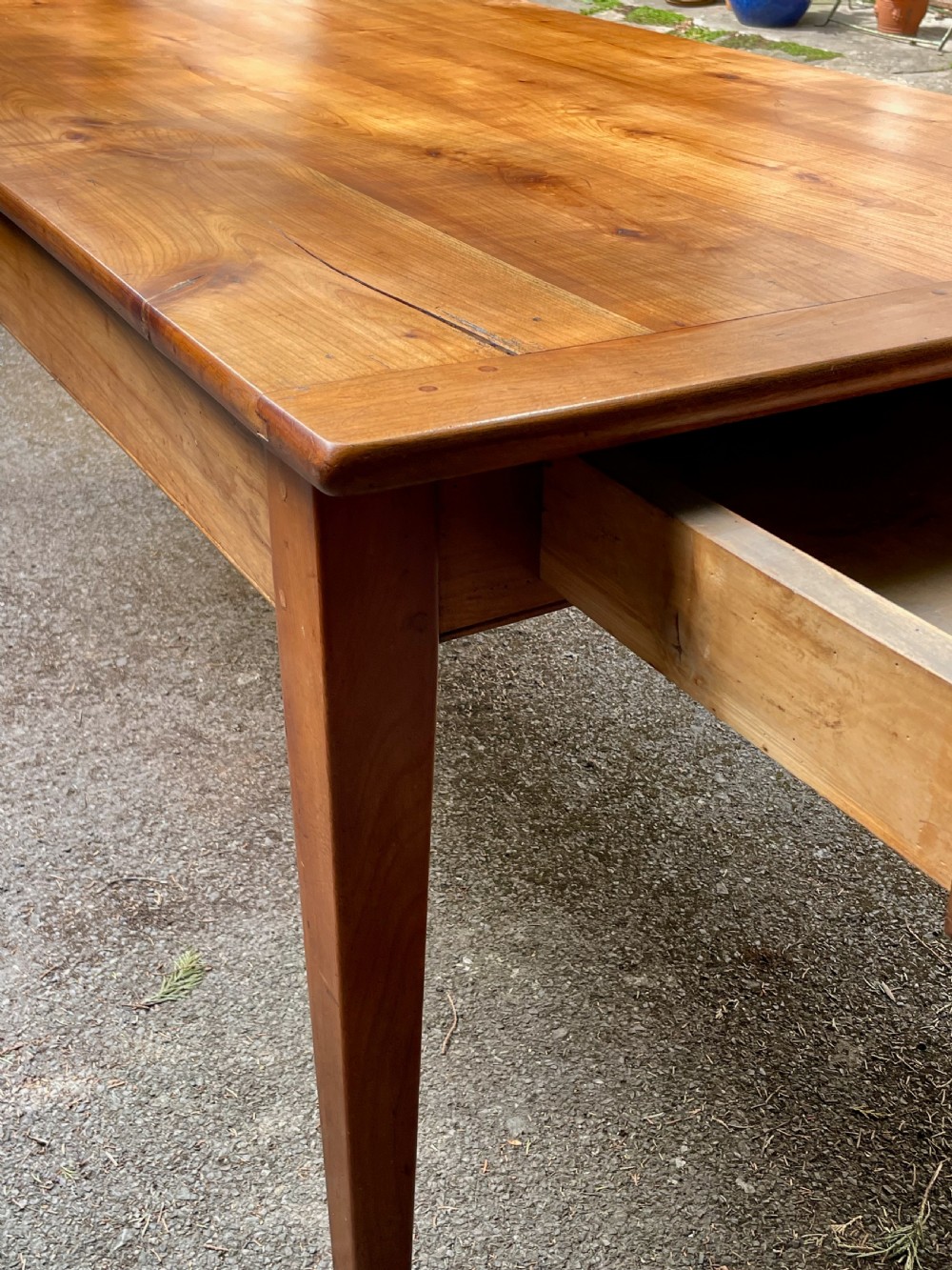 A rectangular wooden refectory dining table with a plank top, breadboard ends, and four tapered legs. View IX
