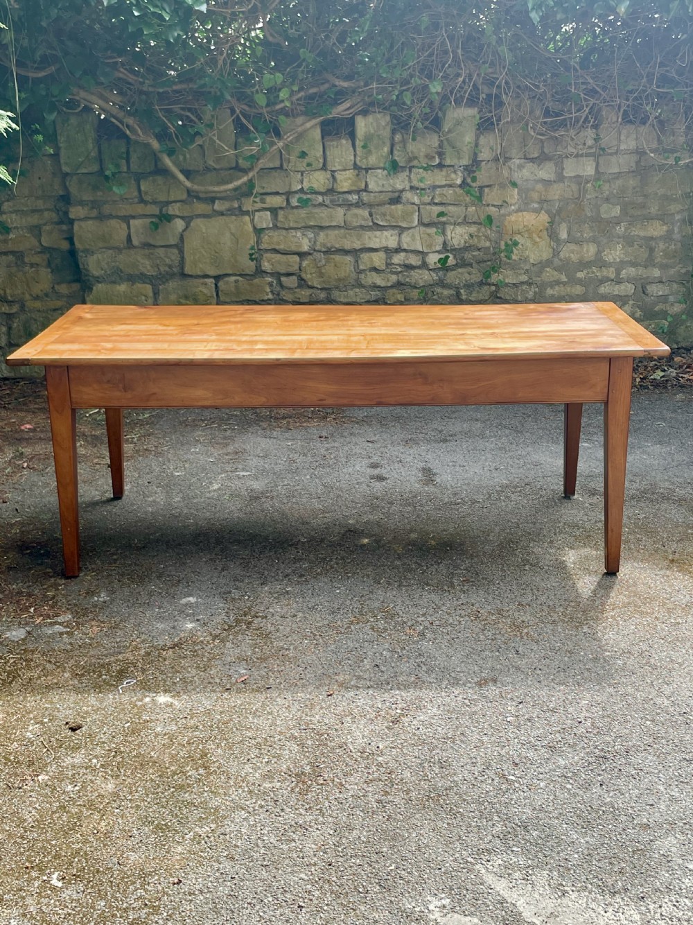 A rectangular wooden refectory dining table with a plank top, breadboard ends, and four tapered legs. View X