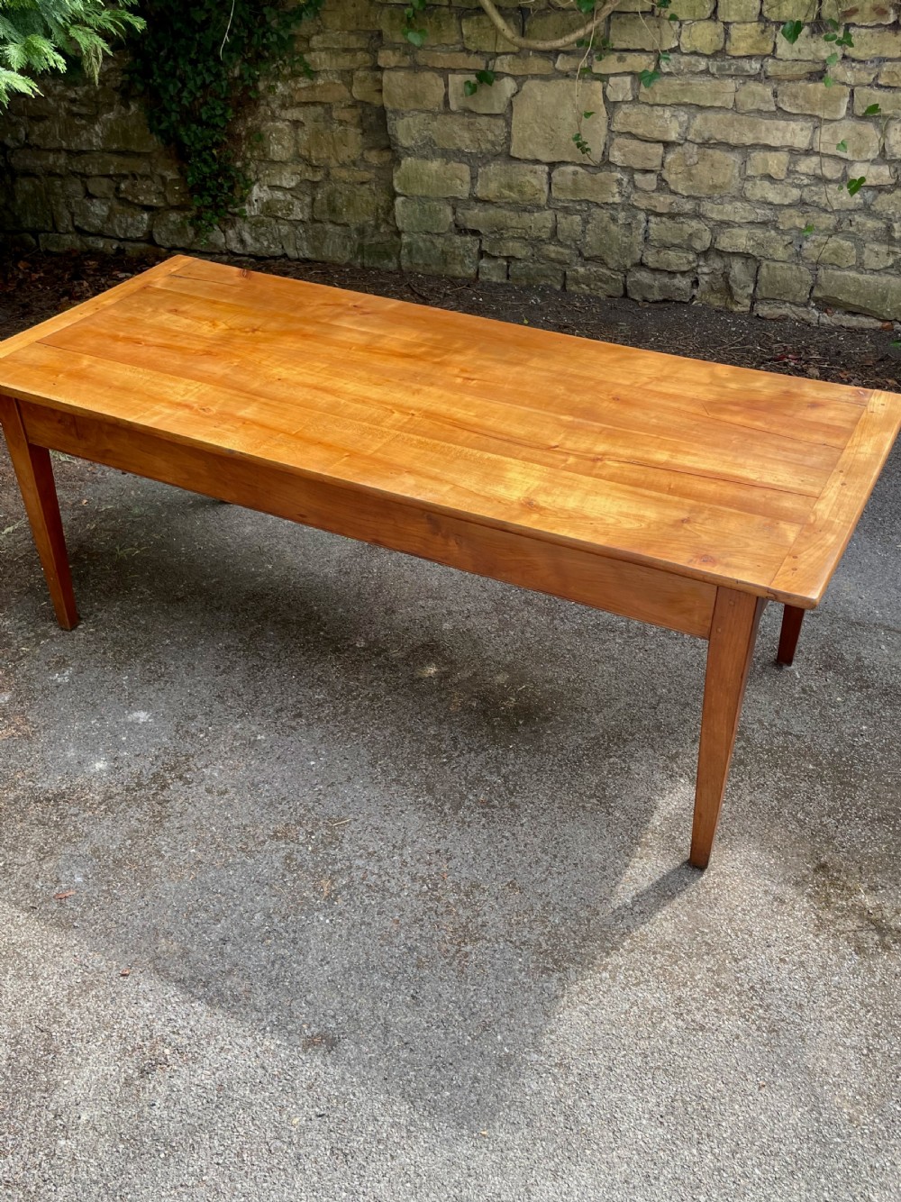 A rectangular wooden refectory dining table with a plank top, breadboard ends, and four tapered legs. View XI