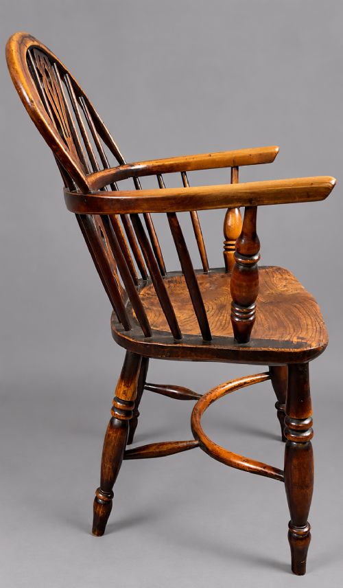 An antique yew wood low-back Windsor armchair featuring a pierced decorative back splat, turned legs, a shaped wooden seat, and a curved crinoline stretcher. View IV