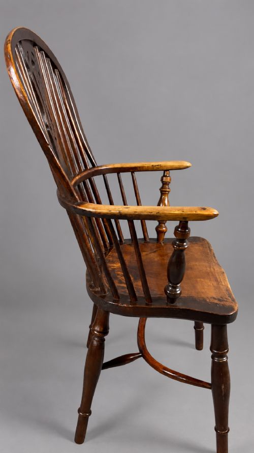 A nineteenth-century high-back yew wood Windsor armchair featuring a pierced back splat, spindled hoop back, shaped elm seat, turned legs, and a crinoline stretcher. View VII