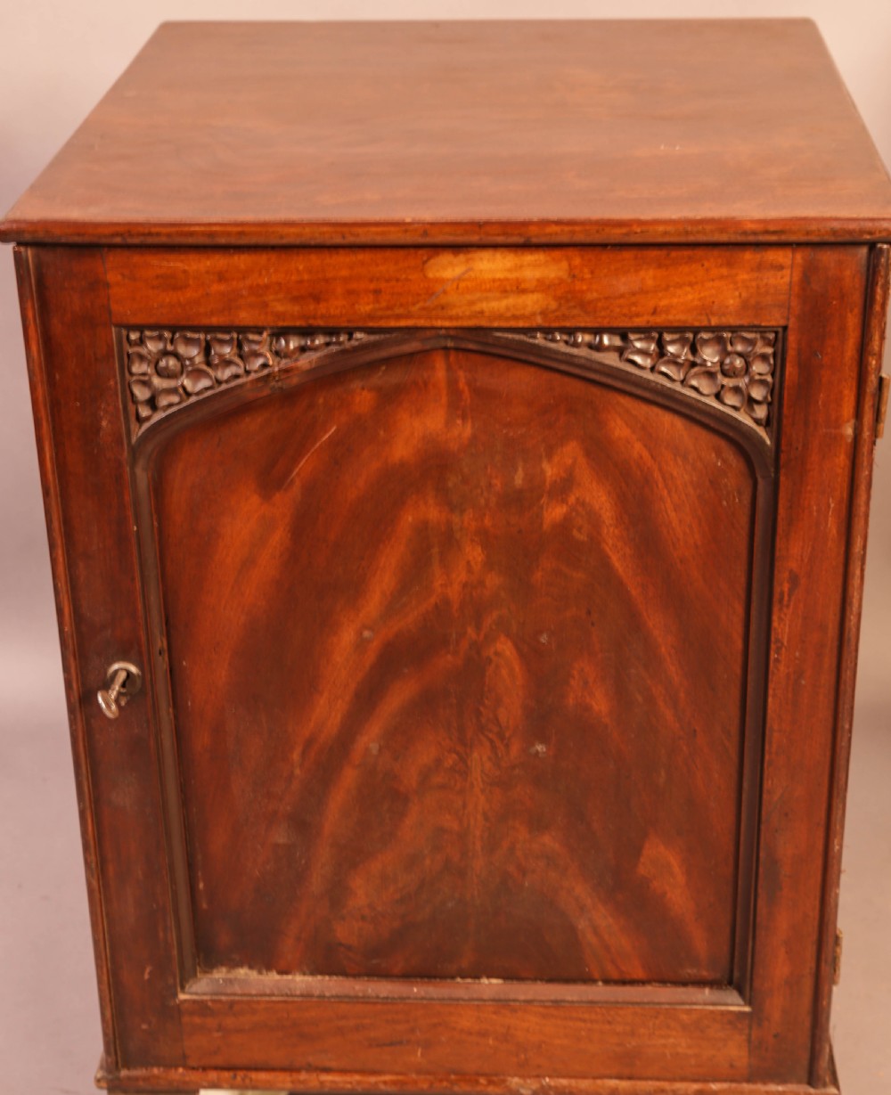 A rich brown mahogany Victorian collectors cabinet with a arched panel door and carved spandrels. View III