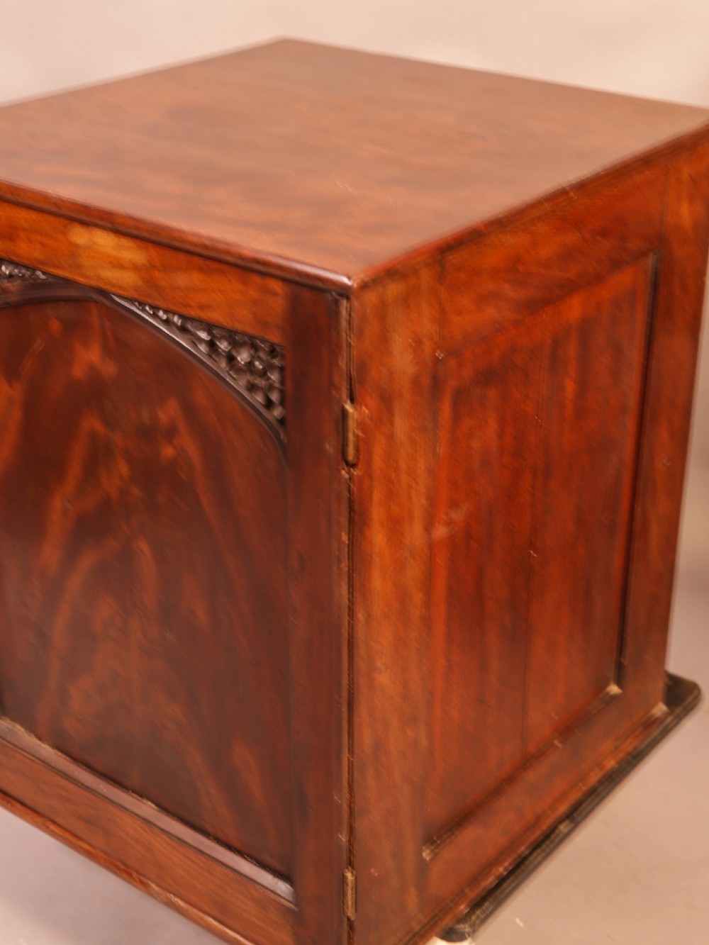 A rich brown mahogany Victorian collectors cabinet with a arched panel door and carved spandrels. View IX