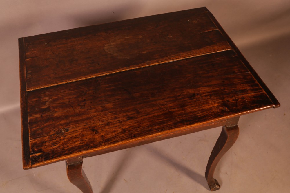An early 18th-century dark oak side table featuring cabriole legs, a single frieze drawer, and a brass drop handle. View III