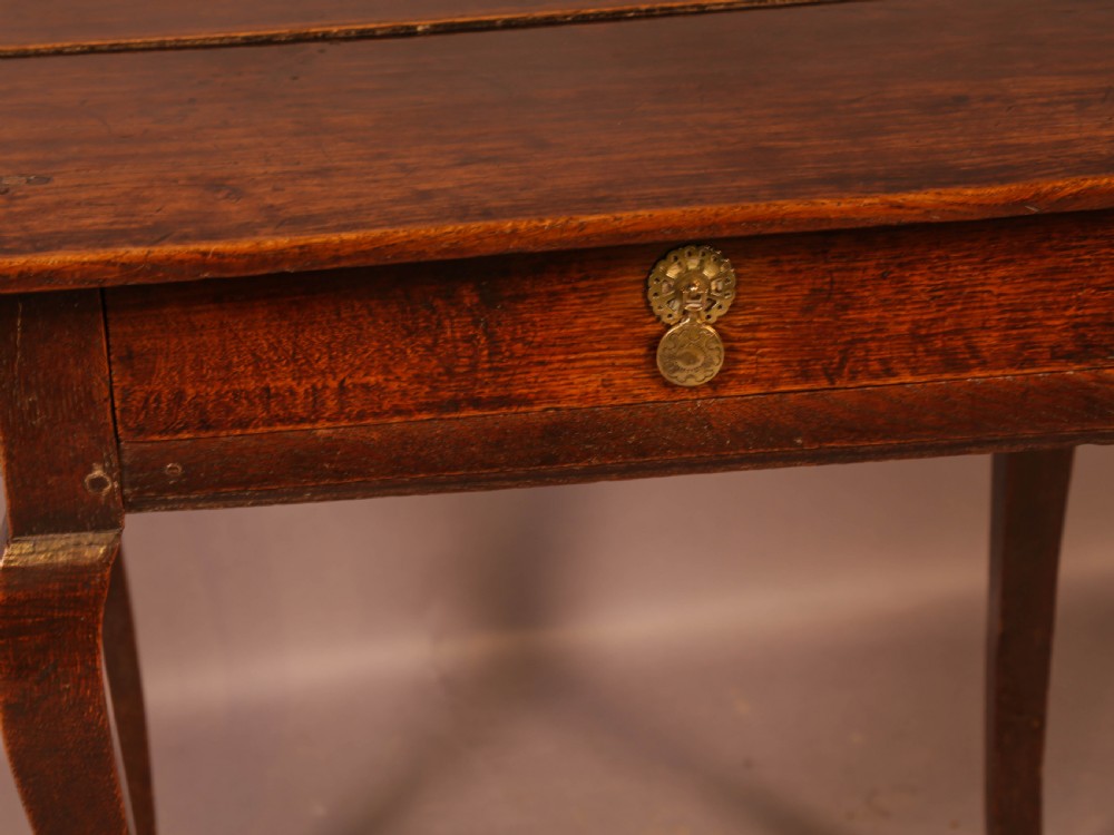 An early 18th-century dark oak side table featuring cabriole legs, a single frieze drawer, and a brass drop handle. View V