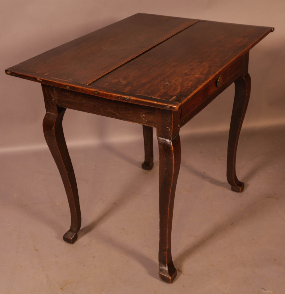 An early 18th-century dark oak side table featuring cabriole legs, a single frieze drawer, and a brass drop handle. View VI