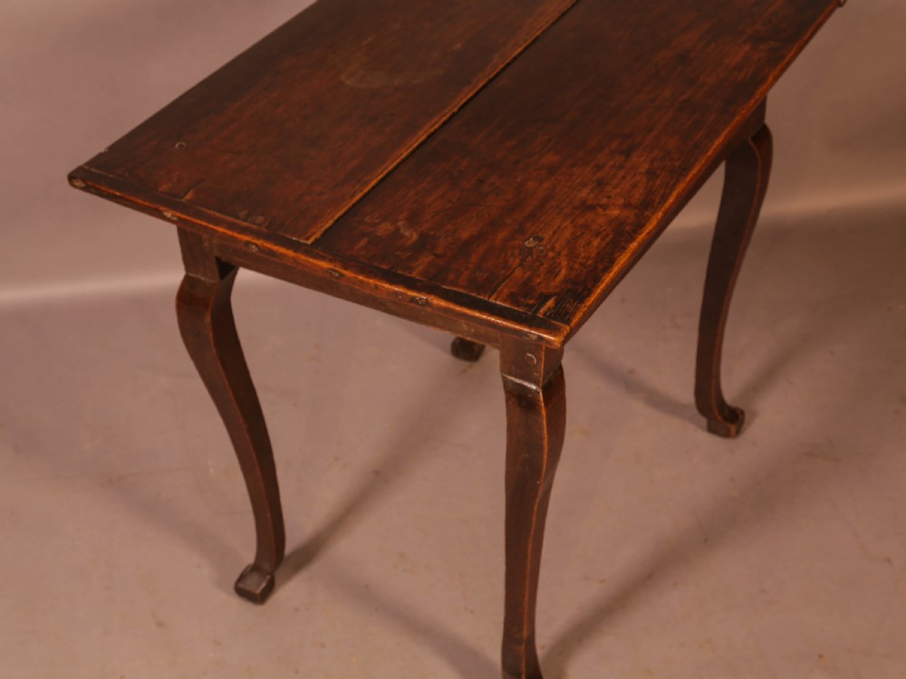 An early 18th-century dark oak side table featuring cabriole legs, a single frieze drawer, and a brass drop handle. View VII