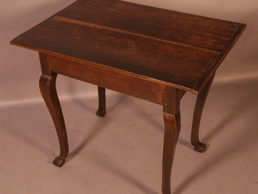 An early 18th-century dark oak side table featuring cabriole legs, a single frieze drawer, and a brass drop handle. View IX