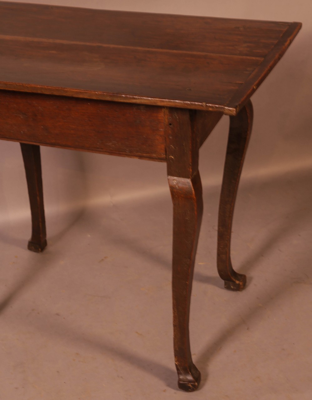 An early 18th-century dark oak side table featuring cabriole legs, a single frieze drawer, and a brass drop handle. View X