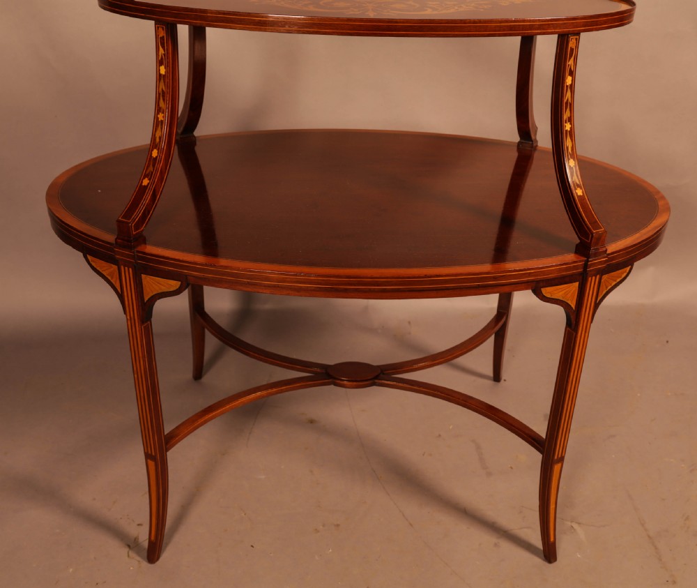 An Edwardian two-tier oval mahogany etagere featuring detailed central floral marquetry inlay, slender curved supports, and swept legs with crossbanding. View VIII