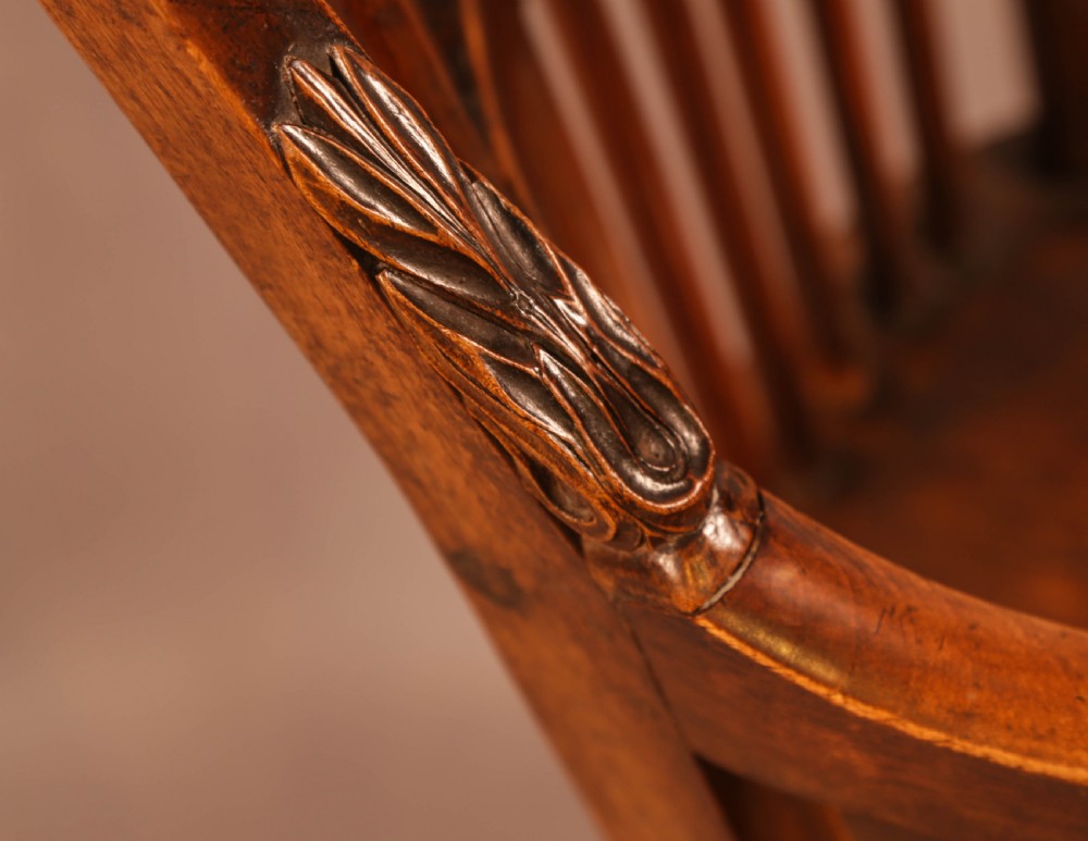 A dark brown antique wooden Windsor armchair featuring vertical spindles, a contoured saddle seat, and hand-carved snake head terminals on the arms and top rail. View IX