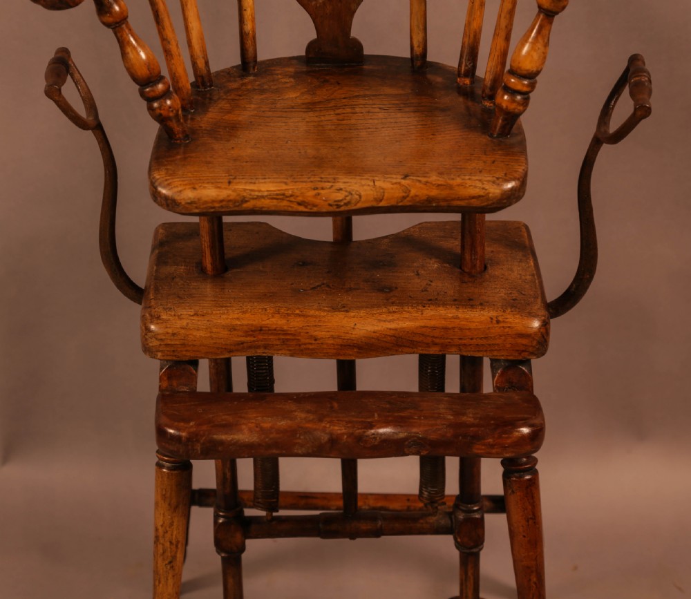 An antique Victorian yew wood child exercise chair featuring a hoop-back top seat, side metal handles, coiled steel springs, and turned legs. View IV