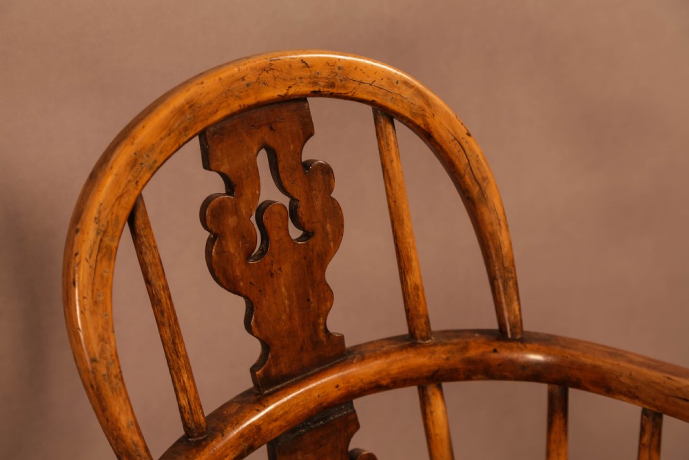 An antique Victorian yew wood child exercise chair featuring a hoop-back top seat, side metal handles, coiled steel springs, and turned legs. View IX