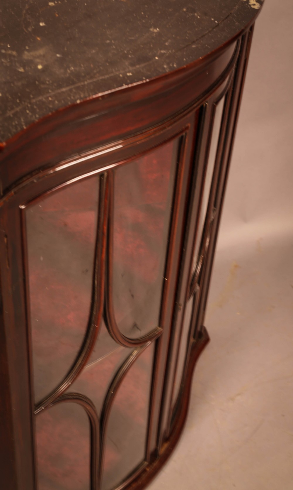 A dark mahogany wall-hanging corner cupboard featuring glazed double doors with serpentine curved fronts and decorative astragal glazing bars. View VI