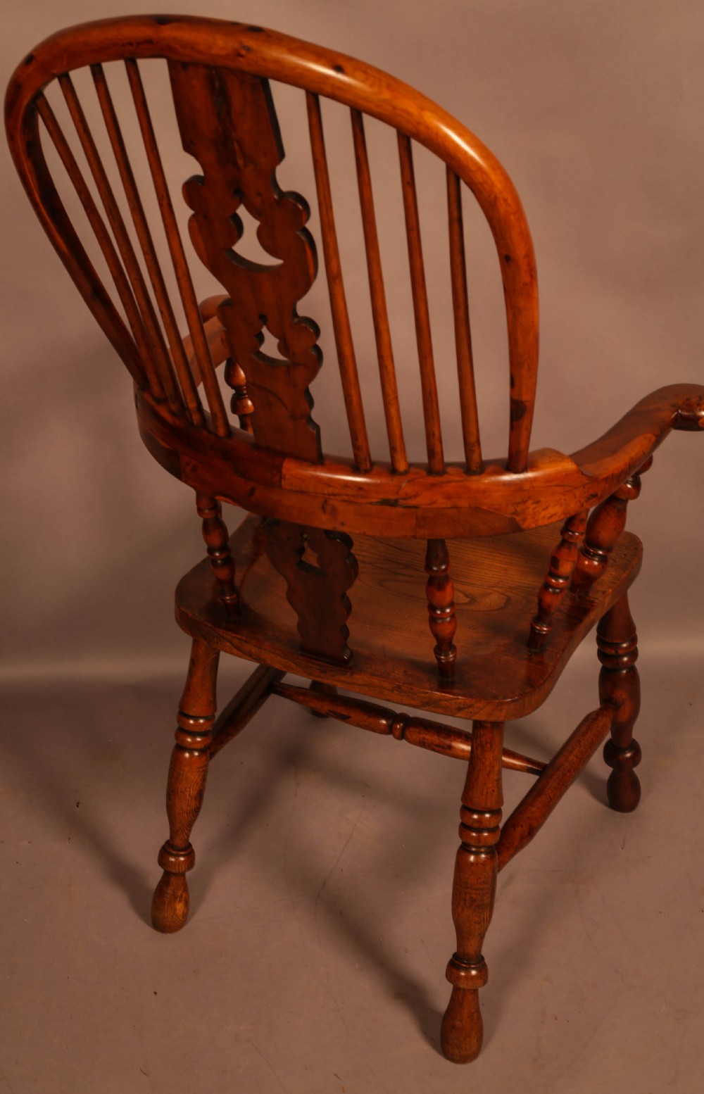 A high-back yew wood Windsor armchair featuring a pierced back splat, spindle backrest, broad armrests, turned legs, and stretchers. View IV