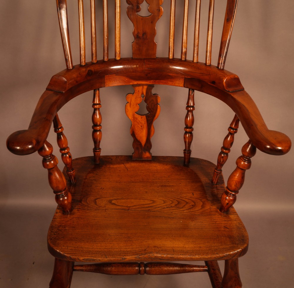 A high-back yew wood Windsor armchair featuring a pierced back splat, spindle backrest, broad armrests, turned legs, and stretchers. View V