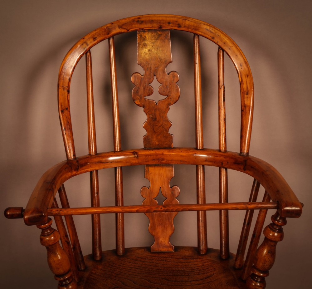 A yew wood Windsor childs high chair with a pierced splat back, turned legs, footrest, and safety bar. View VII