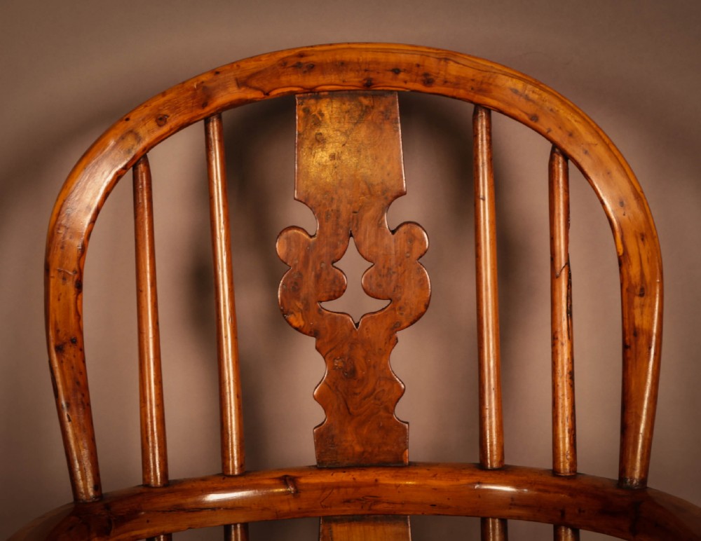 A yew wood Windsor childs high chair with a pierced splat back, turned legs, footrest, and safety bar. View VIII